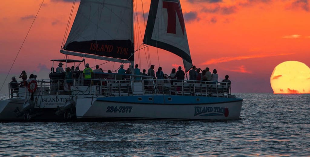 Image of a sailboat sailing at sunset.