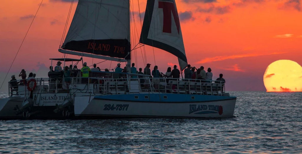 Image of a sailboat sailing at sunset.