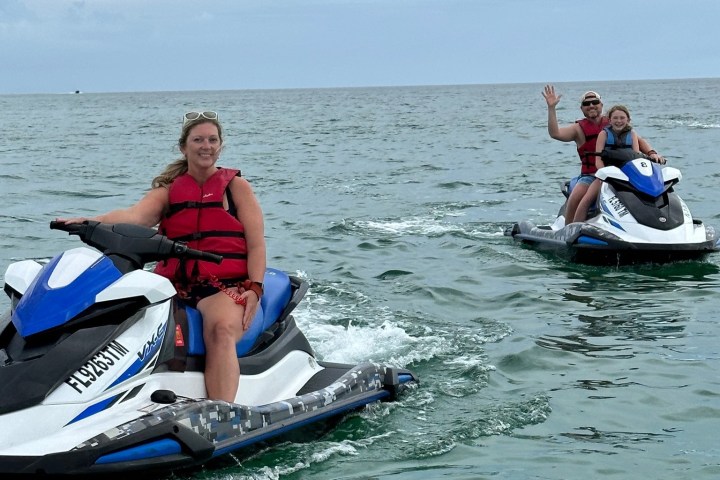 a group of people riding on the back of a boat in the water