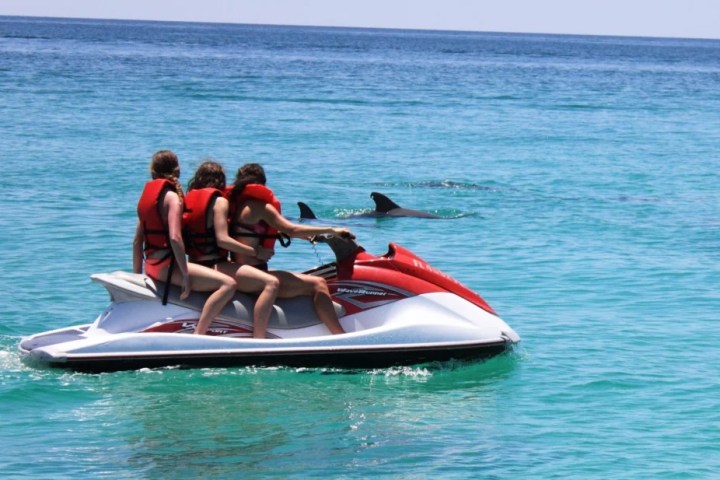 a group of people riding on the back of a boat in the water