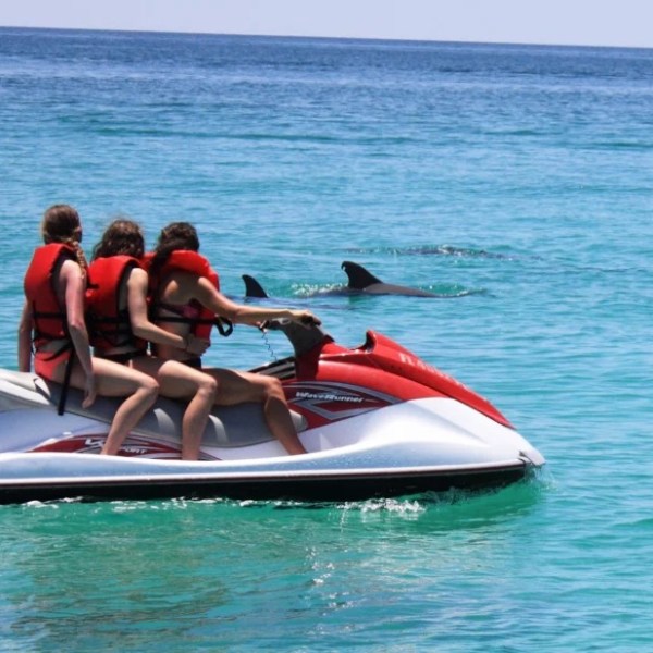 a group of people riding on the back of a boat in the water